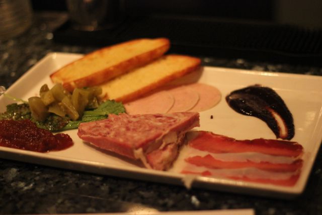 A charcuterie plate started the meal and included cured pork loin, mortadella, and turkey pÃ¢tÃ© along with pickled green tomatoes and a blueberry preserves.