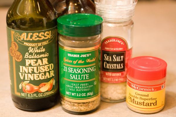 Here are our simple ingredients: White Balsamic Pear Infused Vinegar (we picked up this bottle at Whole foods for about $4 or $5 bucks), Trader Joe\'s 21 Seasoning Salute, Salt, Ground Mustard, and in the dark glass bottle, we have some olive oil.