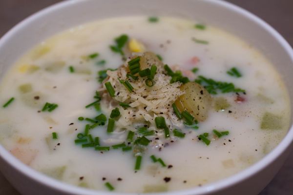 Corn chowder garnished with Parmesan, freshly cracked black pepper and chopped chives.