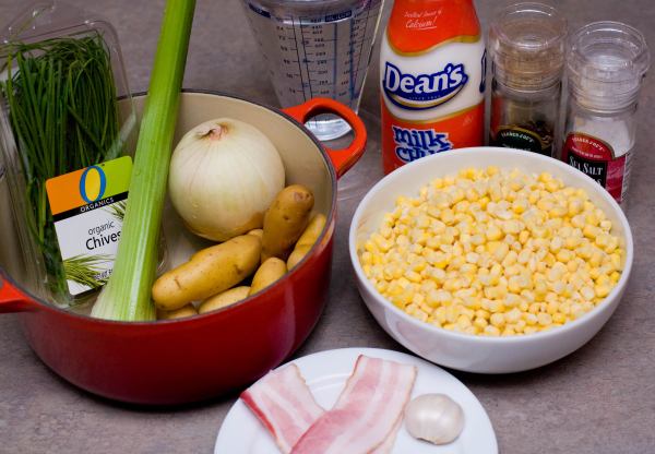 Ingredients: 1 stalk of celery, 1 onion, 1/2 to 3/4 a pound of potatoes, 1 clove of garlic, 2 slices of bacon, 1 pound of frozen corn, 4 cups of water, 1/2 cup of milk (or cream), chives for garnish, salt and pepper.