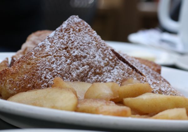 French toast dusted with powdered sugar with side of apples.