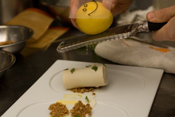 The frozen tube is placed on the plate with granola, a lemon cream, some mint, and then topped with lemon zest.  The smiley face was for the camera\'s benefit. :)