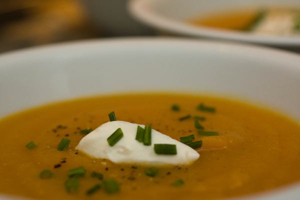 Our pumpkin soup, speckled with black pepper, topped with a quenelle of sour cream and chopped chives.