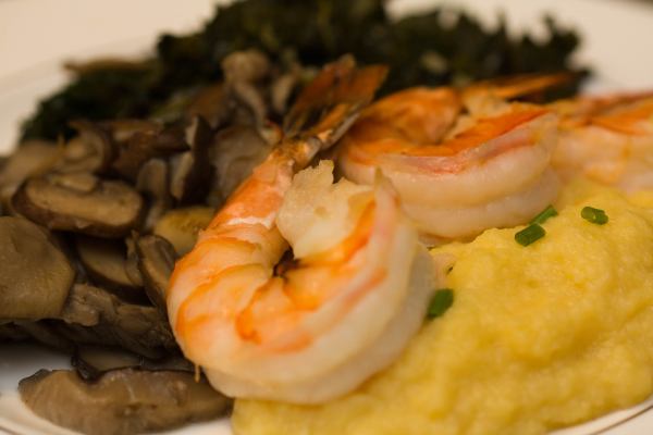 The peeled and cleaned shrimp were tossed in melted butter in which we\'d sauteed shallots and garlic.  We placed them on a cookie sheet and broiled each side for roughly 2 minutes each.  They were placed atop our creamy polenta and served next to our mushrooms and kale.