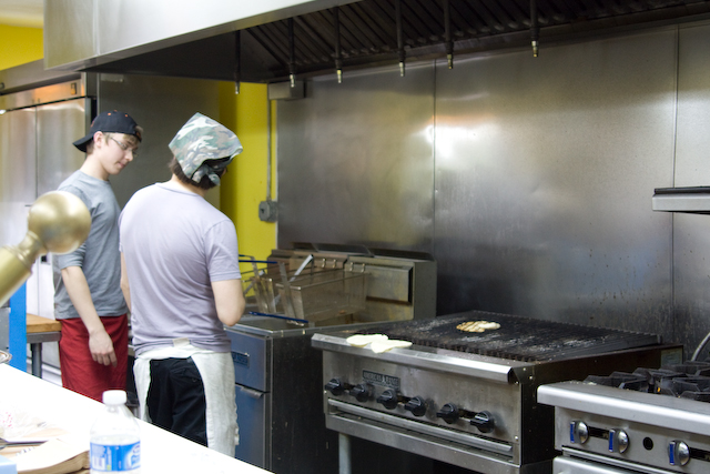 The open kitchen where customers in line watch their food being prepared.