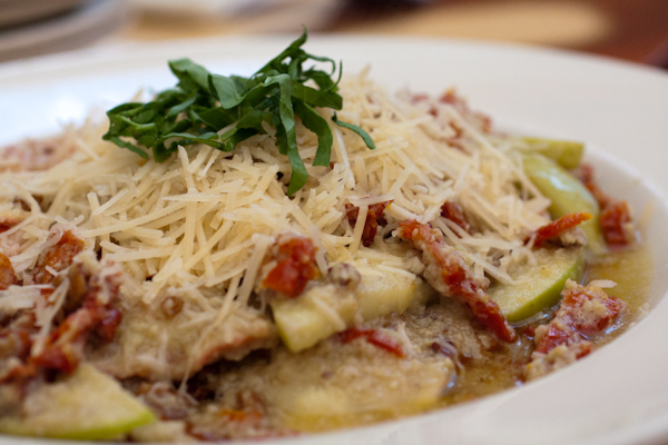 Pasta del Giorno - Homemade raviolis filled with smoked chicken and Granny Smith apples then tossed in an artichoke heart pesto browned butter sauce with sliced apples, sun-dried tomatoes and toasted pecans.