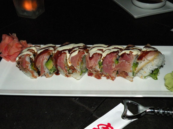 Sushi X\'s \"Five-o\" roll is made with bacon, hamachi, avocado, cilantro, scallions and pineapple mustard mayo. Then it\'s rolled in bacon bits and wrapped with prosciutto. Everything is better with bacon and/or prosciutto.