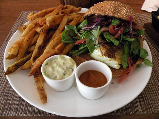 The C-House burger is a hefty slice of black cod, served with arugula, tomato, onion and served with a side of house fries. The fries and house made ketchup are seasoned with African berber spice. Coconut tartar ties the dish together.