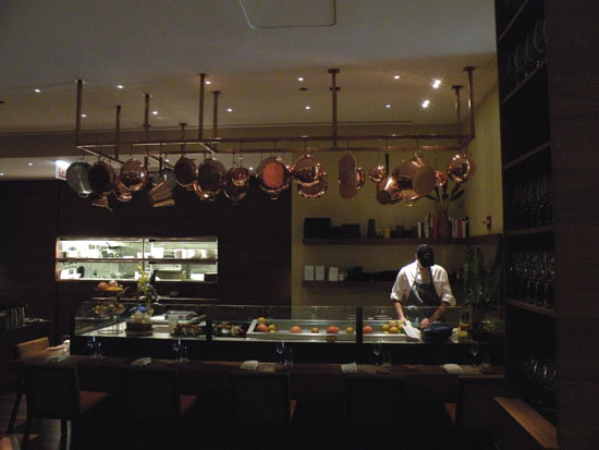 Copper pots and pans hang above C-House\'s raw bar, making for a beautiful accent note to the room.