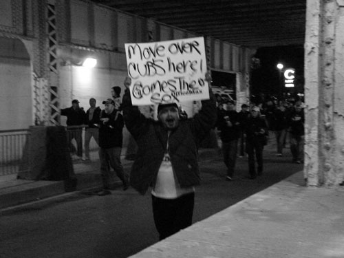 Celebrating in the 35th Street Viaduct, a fan shows that he doesn\'t have his priorities straight.