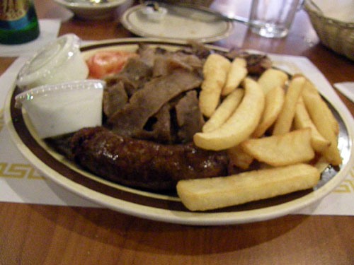 The Greek combo plate, a heart-stopping mix of gyro meat, souvlaki and Greek sausage served with onions, tomatoes, fries, tzatziki sauce and one pita.