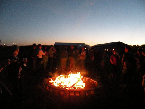 The bonfire burns hot just as the sun begins to set.