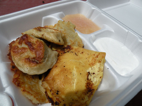 A combination plate of 3 pierogis (one each meat, sauerkraut and mushroom), one cheese blintz and a potato pancake, served with sour cream and applesauce