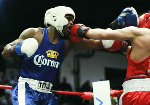 Tracy Rollins, Jr., takes a punch from Ramon Valenzuela, Jr., Friday night. Rollins went on to win the bout and the 165-Open title in the Chicago Golden Gloves tournament.