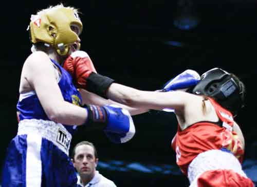 Natalie Jane Malik, left, takes a punch from amateur boxing competitor Amanda Reicke (right). Malik went on to win the 119-pound senior novice division.