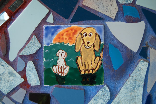 The family dogs are amongst the tiles hand-painted by children in the community.