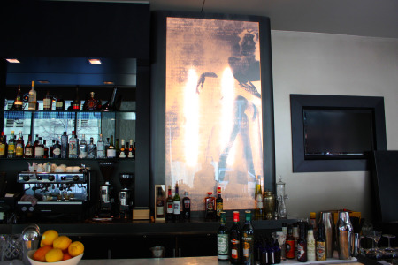 Backlit art behind the bar.