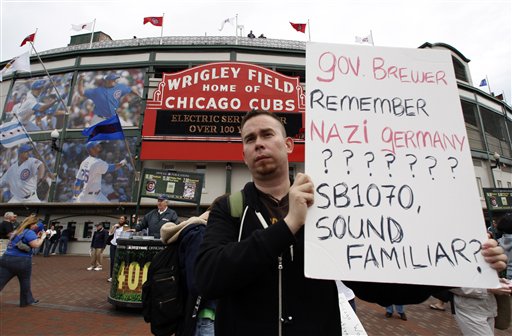 Gilberto Magana of Chicago, holds a sign as he protests at Wrigley Field.