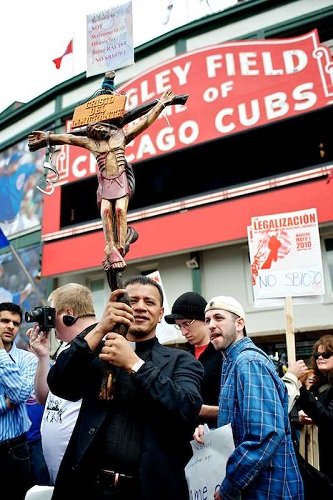 Fr. Jose S. Landaverde carrying a cross at the Arizona Immigration protest at Wrigley Field.