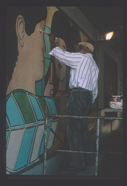William Walker picks up a paintbrush during the 1993 restoration of his original mural.