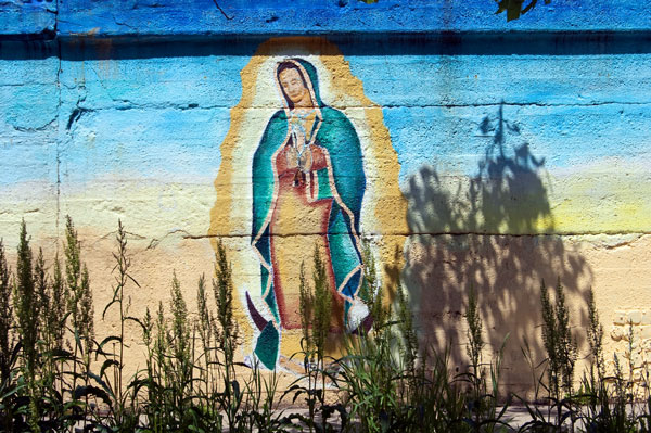 Part of a larger mural, Our Lady of Guadalupe prays on a viaduct wall on 16th Street at Carpenter.