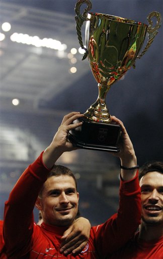 Red Star Belgrade\'s Slavoljub Dordjevic holds the trophy as he celebrates with teammates after they defeated the Paris Saint-Germain during a shootout for the cup.