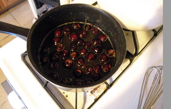 Blanching the cherries in the syrup.