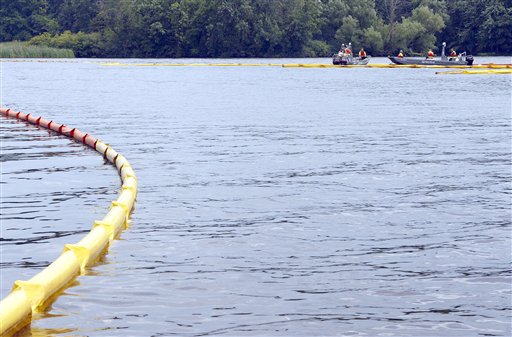 Contract workers for Enbridge, Inc., Calgary, Canada, are seen placing the boom in place across the Kalamazoo River, on Morrow Lake.