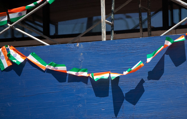 Tiny Indian flags hang on scaffolding on Devon Ave.