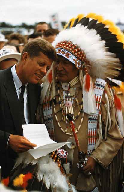 Near Fargo, South Dakota during the 1960 campaign, an earnest chief tries to remind JFK that if his tribe can not get its land back from the white man who spoke with forked land deeds, he could at least get permission to start a casino. Kennedy was there that day to address 100,000 farmers, and I remember it as the day I bought the first two Widelux cameras in town from Helix, and \<em\>Time\<\/em\> ran one of my first 140 degree pictures over two pages, showing the great grasp JFK had over all those farmers, their site caparisoned by big fluttering ribands of red, green and yellow. Great for Kodachrome. It was almost impossible to take a bad picture of JFK.