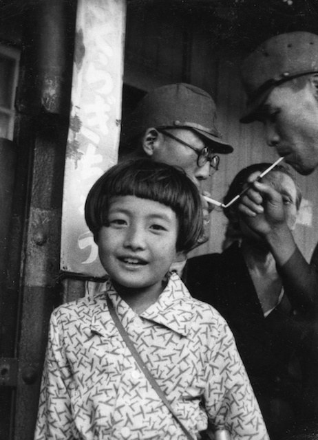 As her daddy lights his opium pipe, we see a survivor of the Tokyo incineration  showing off her blouse with tiny red airplanes adorning it. Perhaps some designer\'s terrible homage to the B-29s which roamed their skies and destroyed their cities and thousands of lives.