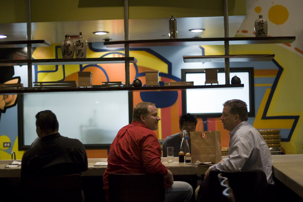 The long sushi bar and colorfully graffitied walls of Union\'s main dining room.