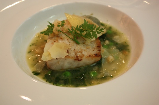 Wild striped bass with spring \'minestrone,\' pesto, croutons and shaved artisan cheese.