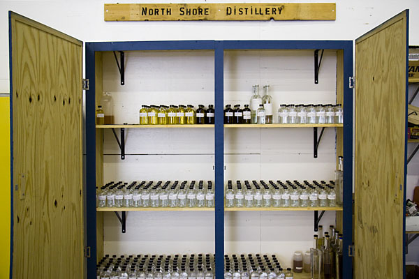 A closet on the back wall of the distillery holds hundreds of small bottles, each containing a sample from a past production run.
