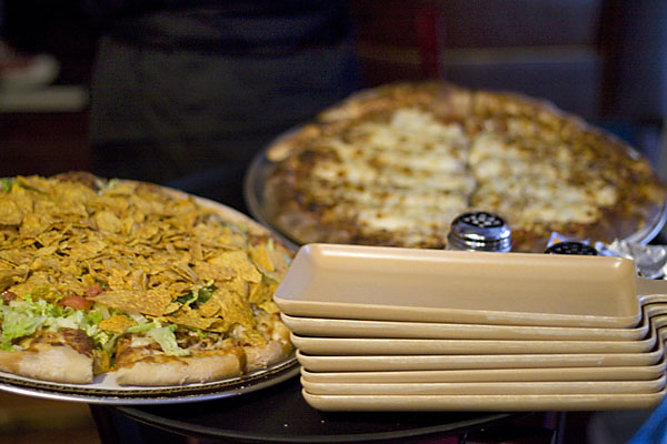 At left, Roots\' signature Taco pizza, topped with seasoned tortilla chips and other goodies.