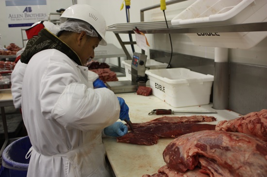 An expert butcher, taking apart a loin.
