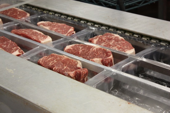 Strip steaks, in the packaging machine.