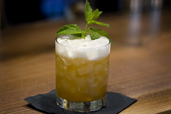The Whiskey Plum Sour, garnished with mint and topped with a head of egg white froth.