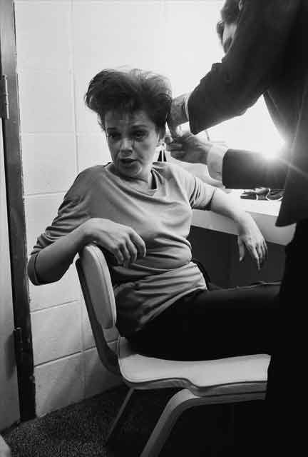 Judy Garland, early 60s -- between pills and drinks, backstage at the Arie Crown Theater before a concert. On the phone she was telling one daughter it was preferable to marry a divorced man than one who\'d never been married. \"He\'ll respect you more.\"  Garland has many photo collectors and several of them regard this take as one of her late milestones. She is generally regarded as having had, as a teenager, the best voice ever given to a woman.