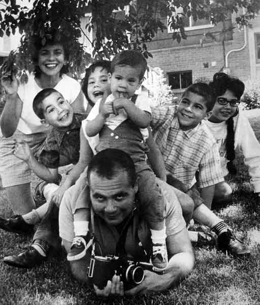 I used to do some of my 50 Mafia stories for the venerable \<i\>Saturday Evening Post\<\/i\>. This was the picture of me \"supporting\" my family in my backyard. Around my neck is a brand new Nikon 250-exposure sequence camera, modeled on the old Luftwaffe  Leicas that I used to shoot down. (Well, I have credit for one from the nose turret of Sweet Sue!) (Â© Art Shay)