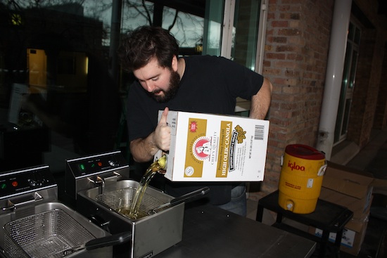 Josh pouring oil into the fryers.