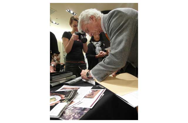 Dr. Lewis autographs some recent purchases of his work at Mark Shale clothing store on Chicago\'s Michigan Avenue. \r\n