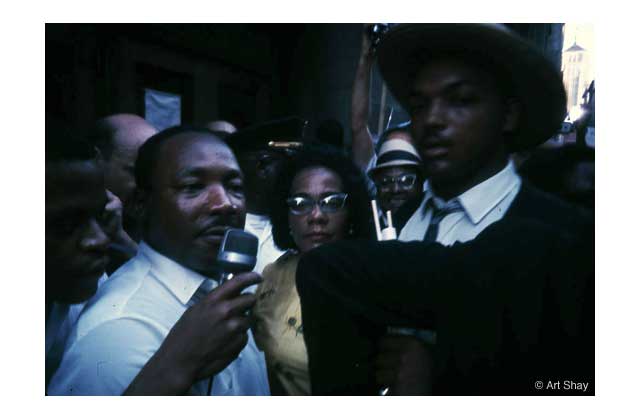 1966 Martin Luther King, Jr. and his wife Coretta, protested Chicago\'s tough demands on blacks by taping their demands onto the door of City Hill, like his namesake Martin Luther did in the 1500\'s. Jesse Jackson stands nearby to weigh in during his early love affair with the news camera. \r\n