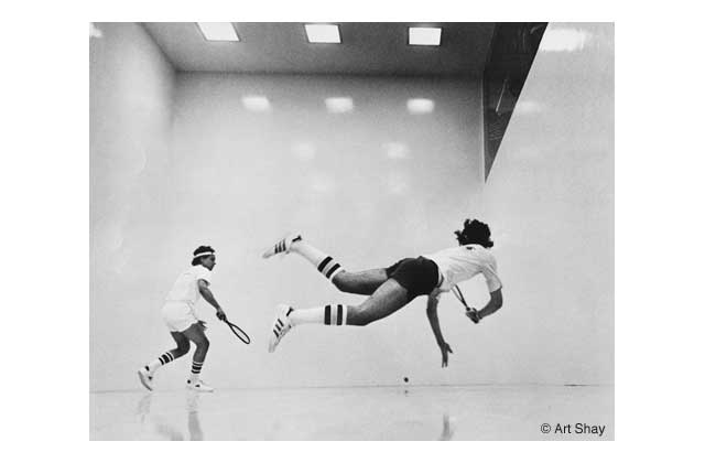 One of the racquetball equipment manufacturers (who bought it for an ad in the mid 70s) called this\r\n\"The best racquetball picture ever made.\" Its title: \"Killshot\" and depicts the often airborne Jerry Hillecher beating Ben Koltun in a Long Island, NY tournament. Camera fans: Nikon FM, 3 frames a second, \r\nTri-x film at 1600ASA, 1/250th, 58mm F 1:4 lens wide open. Through the glass back wall. Just a week ago at my Hall of Fame induction Hillecher thanked me again for the 30x40 inch blow-up his father bought from me. \"It\'s on my wall and everyone gasps as they walk in.â He still proudly remembered his left thigh aching for days after he landed. Look at that kill shot going in!\" He thanked me again... after 40 or so years!\r\n