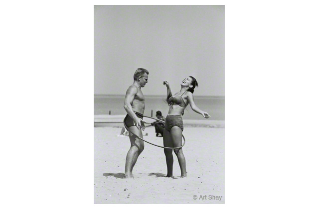 During the hula hoop craze of the 1950s a well-conditioned couple cavorts for \<em\>Life\<\/em\> magazine on Chicago\'s Oak Street beach. \r\n