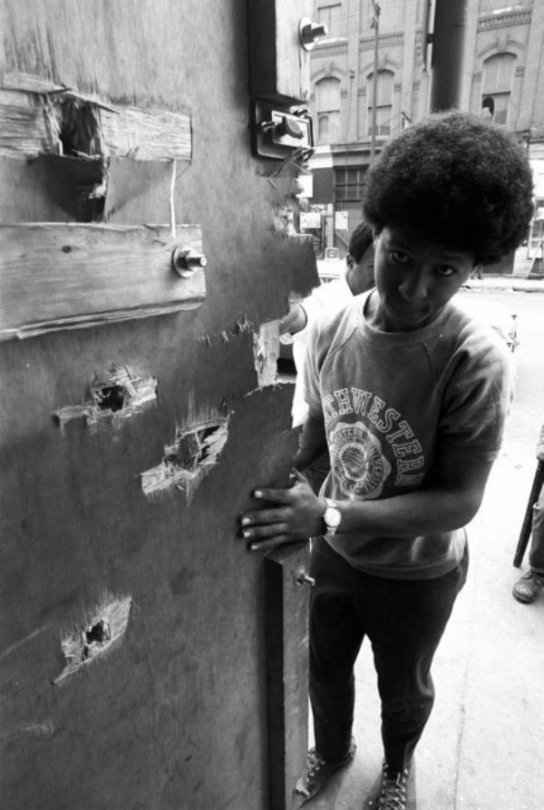 The morning after an out-of- control police squad tried to kill a Blackstone gang leader named Fred Townsend and machine-gunned the door behind which he was sleeping, a neighborhood kid tells of the gunfire. (Â© Art Shay)