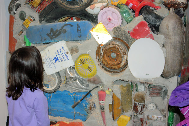 A young visitor contemplates the \"Garbage Wall\" created by the estate of Gordon Matta-Clark for the NRDC booth.