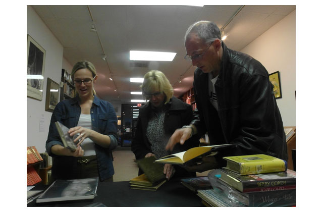 One of Leslie Hindman\'s top auctioneers who led the in-store sales, Mary Kahoke, checks prices on the handful of books bought by Josh and Signe Murphy, friends of Florence and mine. With their two adolescent daughters, in Florence\'s last months, the Murphy family came to our house three or four times and, working as a team cooked sumptuous dinners for us on their own dishes and, after dinner, cleaned up like professionals. When the weather permitted several times  they trekked us all to the Botanical Gardens restaurant so the dying but still smiling Florence could enjoy one of her favorite places. On these pages a few weeks ago you saw 15-year-old India Murphy wearing one of the colorful skirts Florence left behind.\r\n