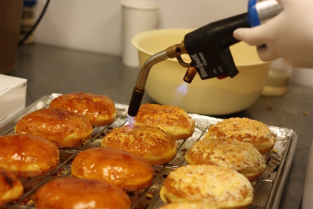Torching the creme brulee doughnuts.