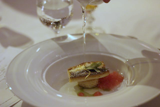 First Course: Mackerel with Crisped Rice Cake, Sorrel Oil, and Grapefruit ConsommÃ©.